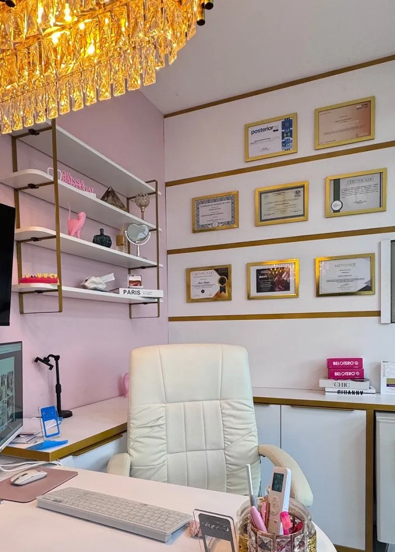 Sala com lustre, certificados e poltrona
